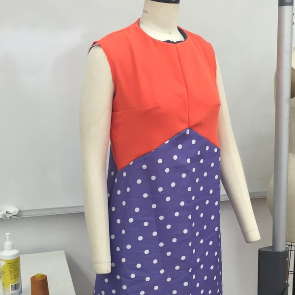 An orange and purple polka dot dress on a mannequin in a pattern making class