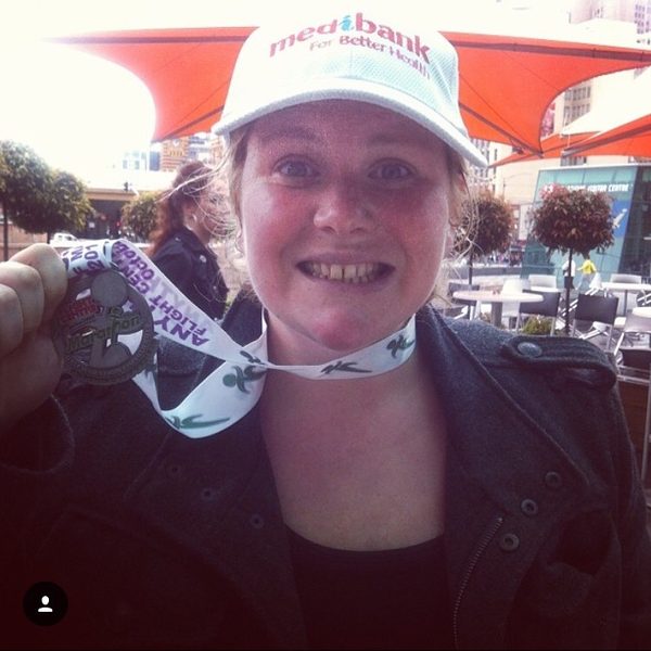 Nikki holding up a half marathon finisher medal