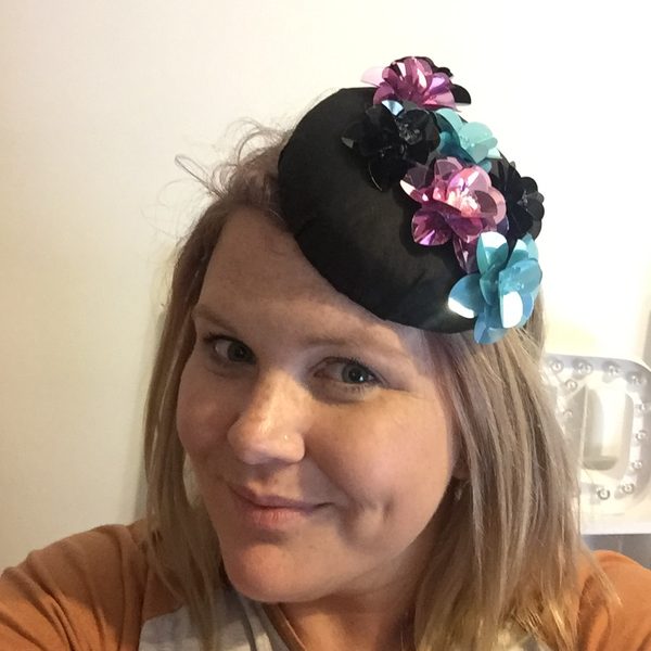 Nikki wearing a black fascinator with sequin flowers