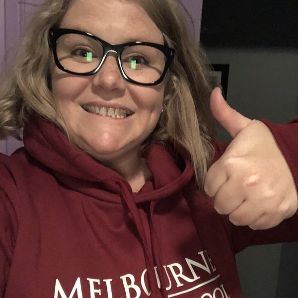 Nikki in a Melbourne Business School hoodie giving a thumbs up