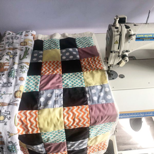 A patchwork quilt under a sewing machine