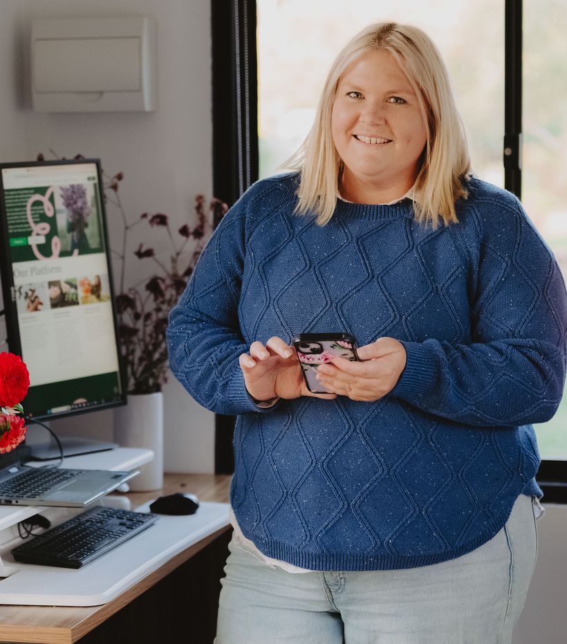 Nikki at her desk, phone in hand