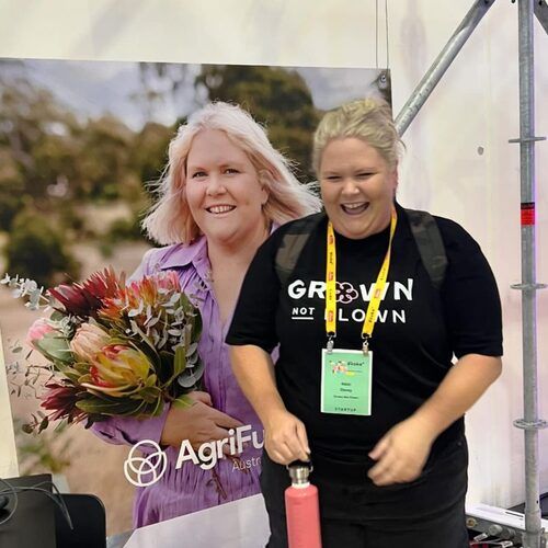 Nikki in a Grown Not Flown t-shirt beside an AgriFutures banner